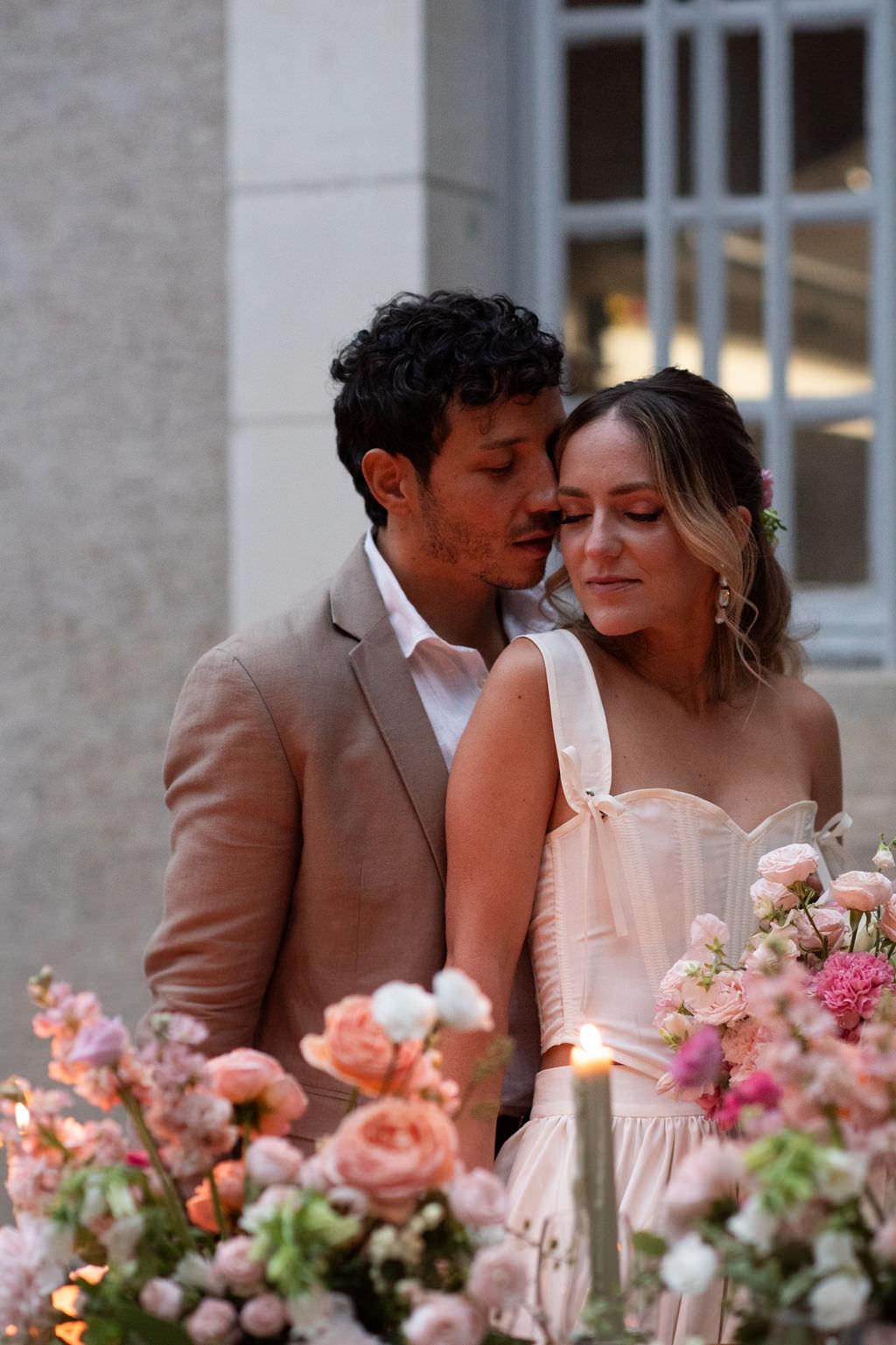 A whimsical couple at a french countryside wedding surrounded by florals and candlelight
